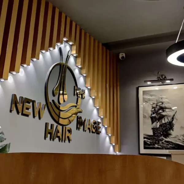 Gold 3D New Hair Image logo on the wall above the reception desk
