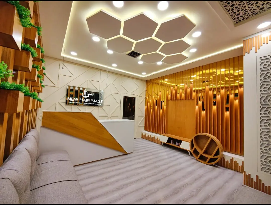 New Hair Image reception with illuminated logo, hexagon ceiling lights and gold slat wall